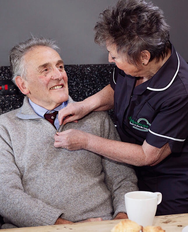 Carer assisting elderly man